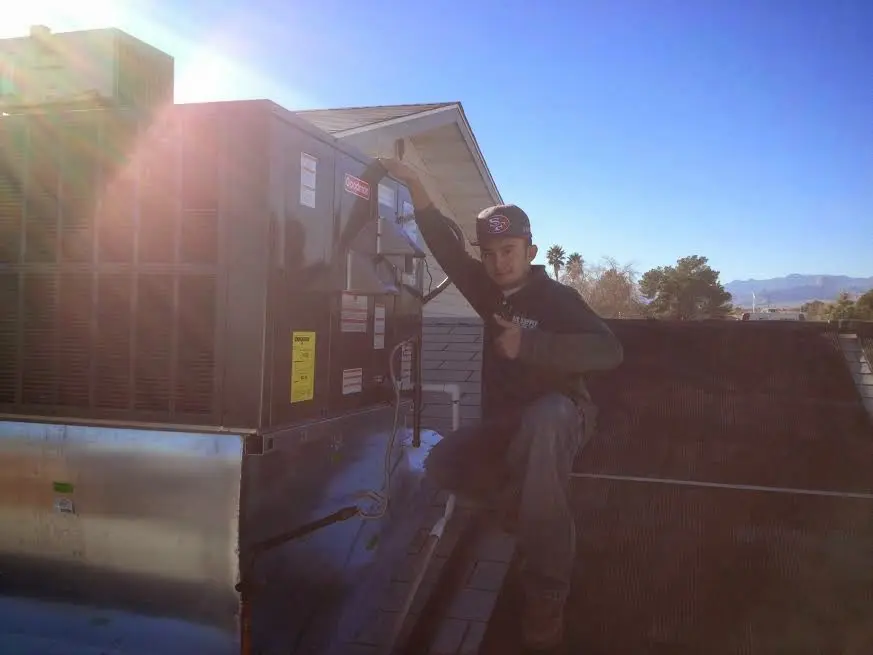 HVAC technician performing AC Tune-Up on a rooftop unit in North Hobbs